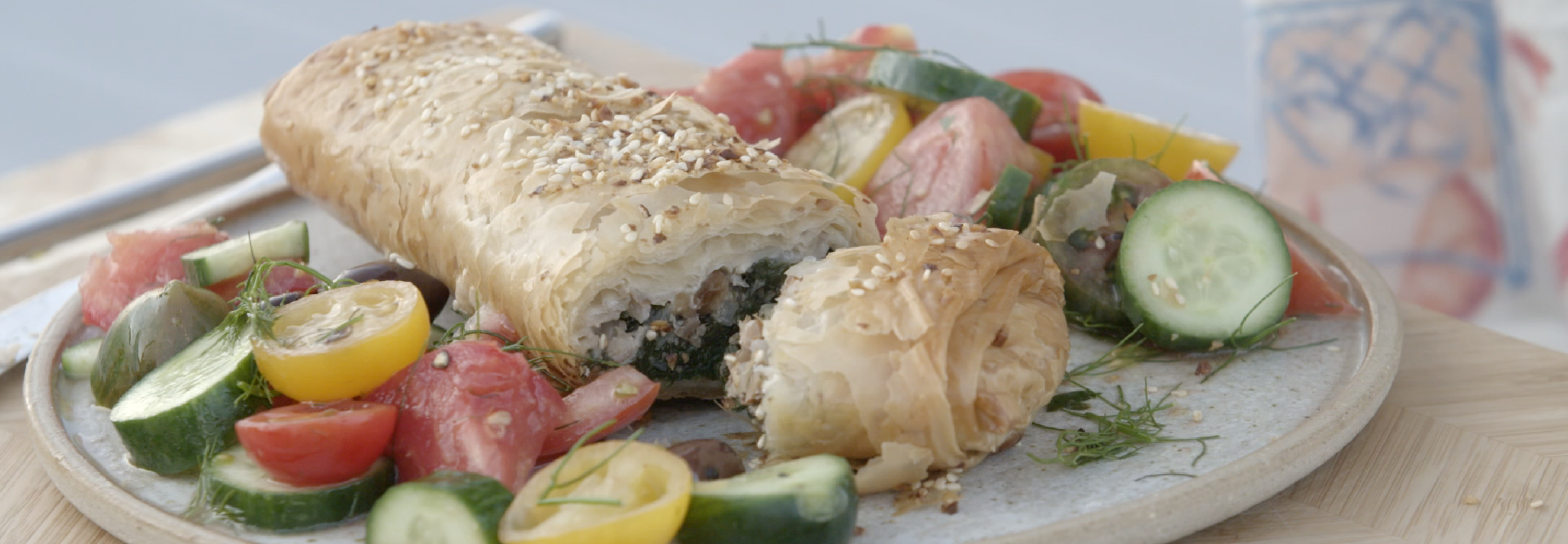 Greek inspired pastry dish with cucumber and tomato surrounding